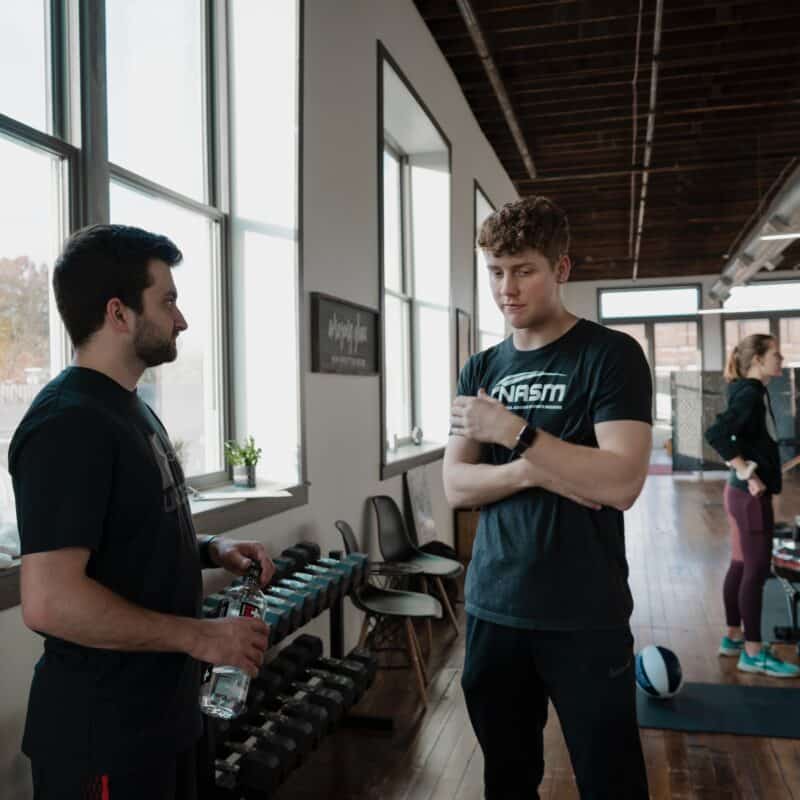A gym employee discusses the positive impact of gym membership software to a member.