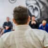 A BJJ teacher stands in front of a fully booked class, ready to begin after his students booked an advanced session using the martial arts club member app.