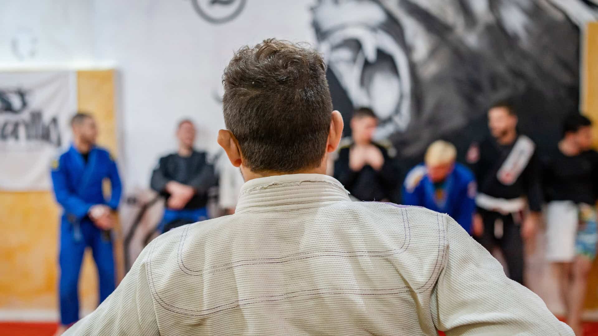 A BJJ teacher stands in front of a fully booked class, ready to begin after his students booked an advanced session using the martial arts club member app.