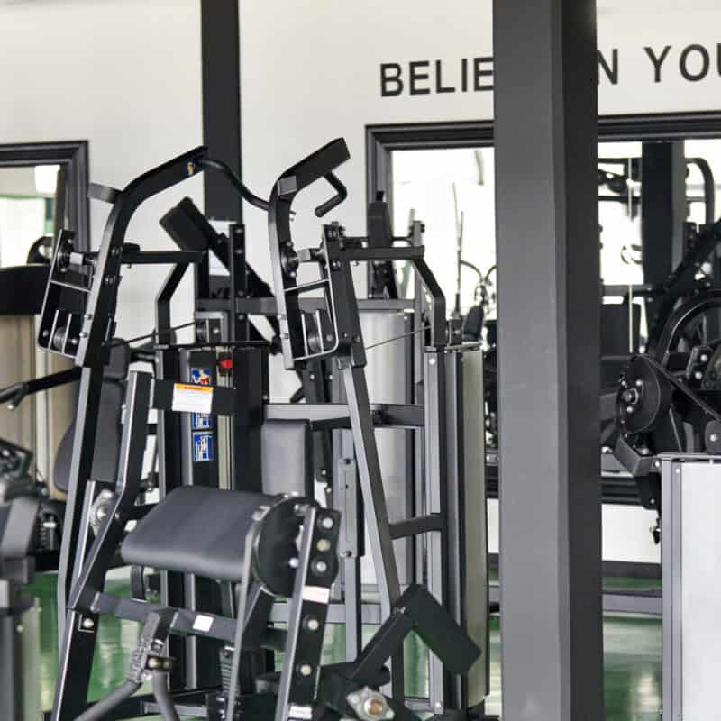 A gym with various exercise machines and motivational phrases on the walls, seamlessly managed with cutting-edge gym software.