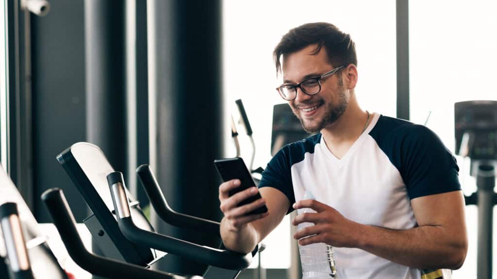 Member smiles as they receive an automated message from their gym celebrating their 10th visit.