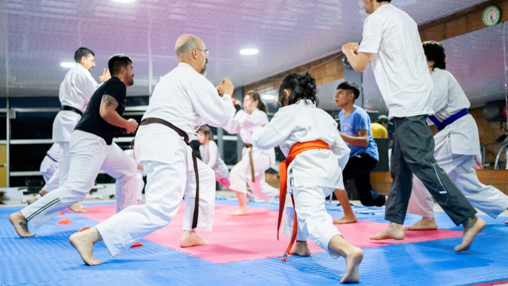 A class full of karate students engage in a warm-up exercise after joining the club online in the winter.