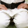 A judo instructor sits on the mat after reviewing his membership figures and setting up an automation in his club management software to re-engage lapsed members.