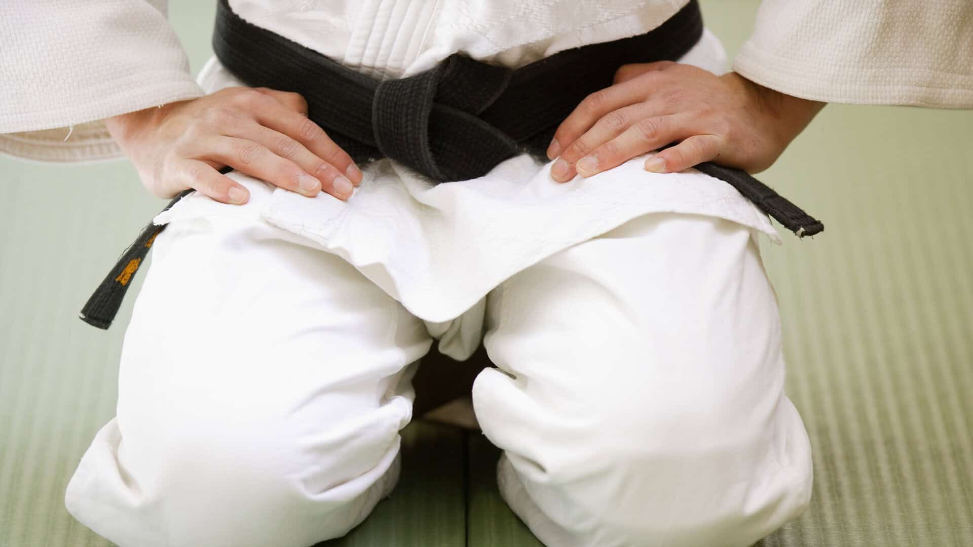 A judo instructor sits on the mat after reviewing his membership figures and setting up an automation in his club management software to re-engage lapsed members.