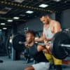 Weightlifter receives personal training after booking a session through a free member app and paying by card.