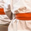 New martial arts students sit on a mat ready for their class after paying for their memberships by card.