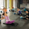 Women take part in a beginner’s pilates class after joining online using exercise class booking software.