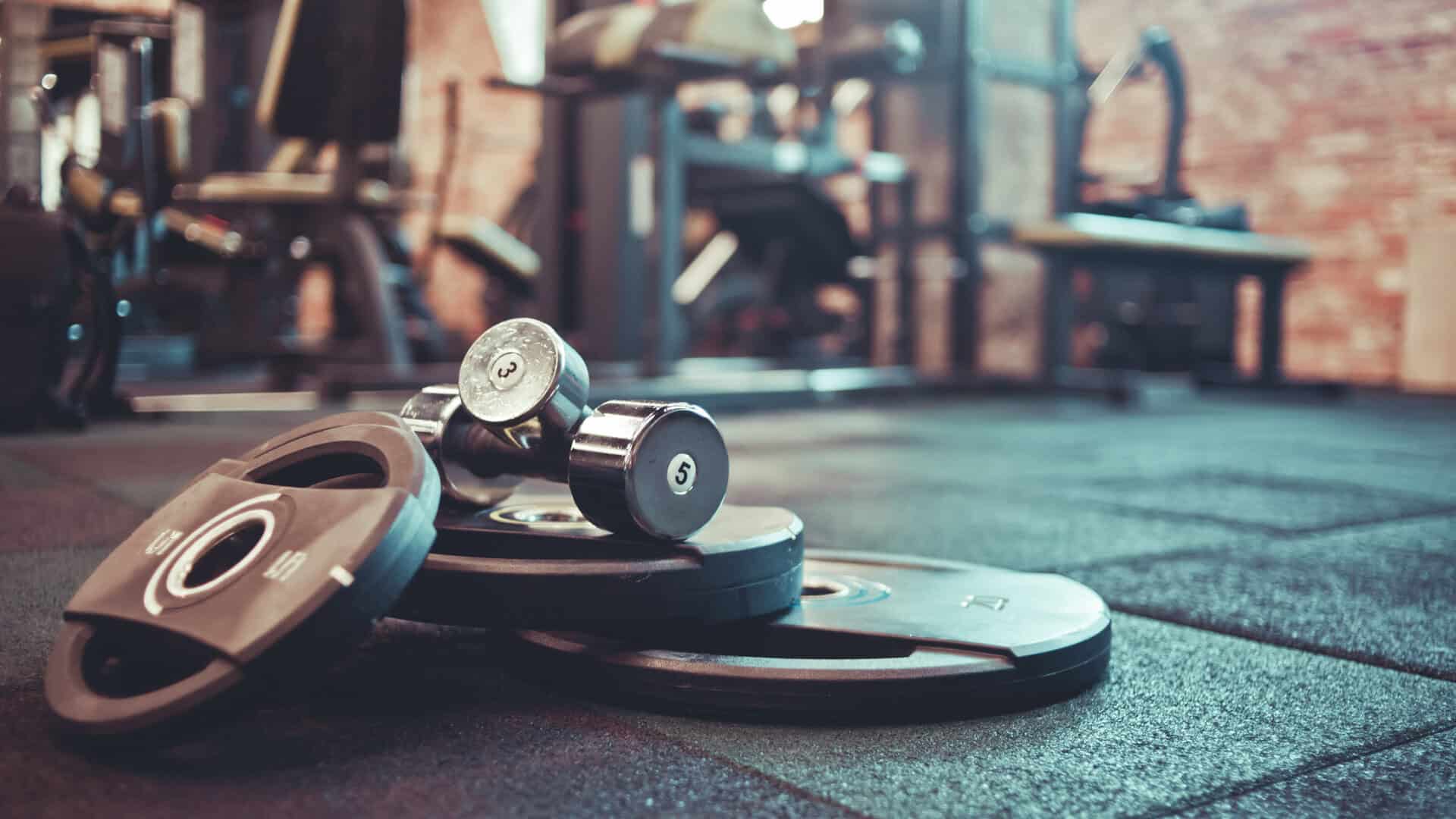 Dumbbells and weight plates on the floor of an independent gym ready to be used by their loyal membership base.
