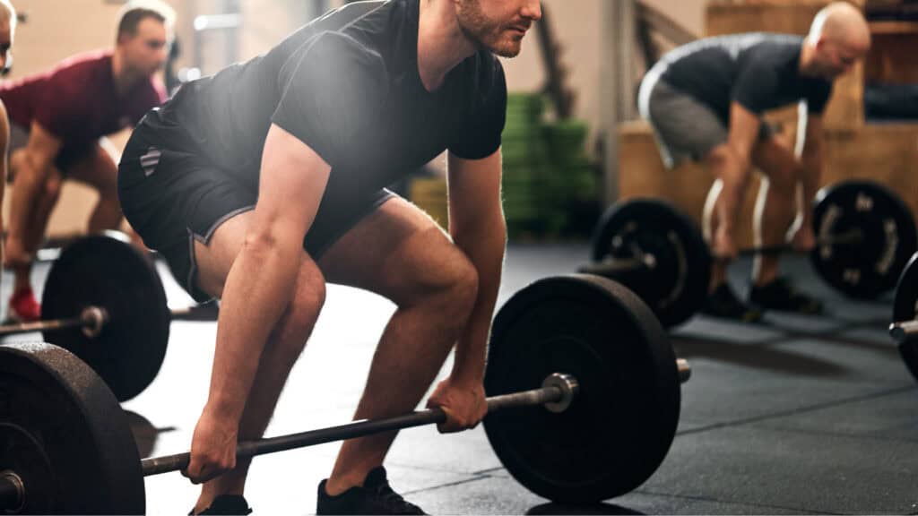 Gym staff training together after setting business goals for their gym; with plans to use gym management software to achieve them.