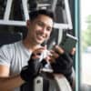 A gym owner smiles after checking their software and seeing their email campaign has converted ten new members.