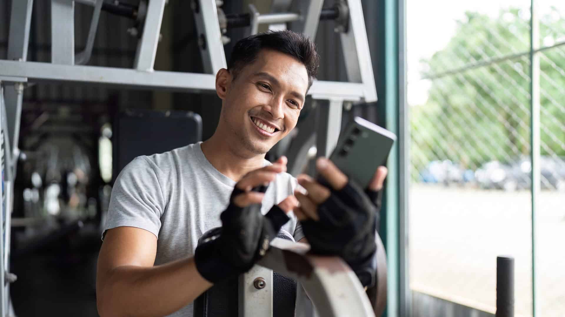 A gym owner smiles after checking their software and seeing their email campaign has converted ten new members.
