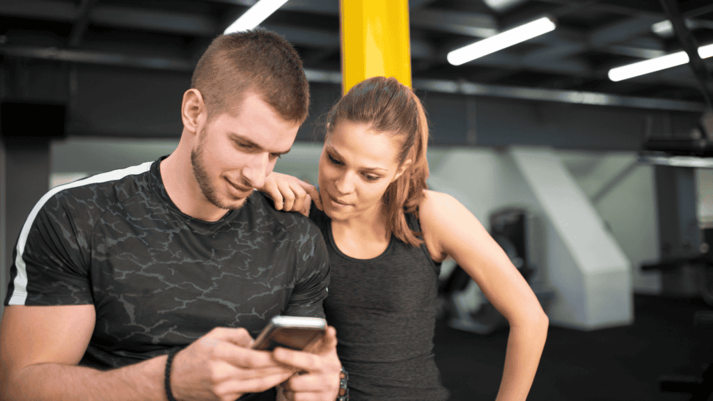 two people in the gym looking at a phone