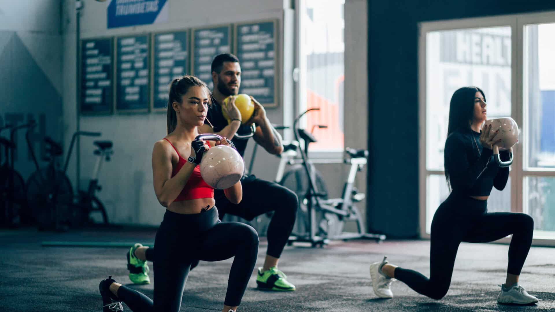 Group of people working out at the gym after upgrading their memberships in their member app to include private group training sessions.