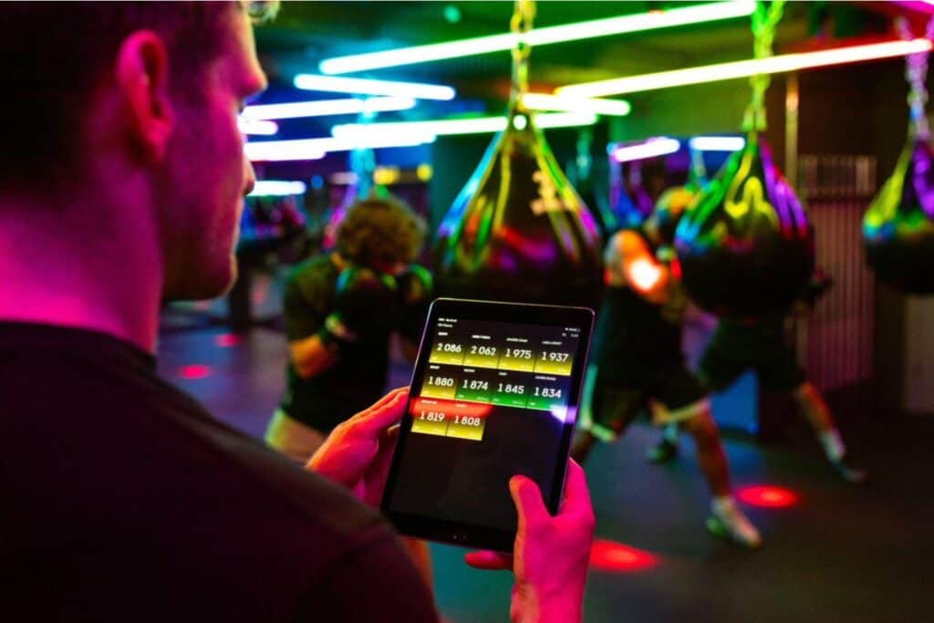 Gym owner happily working on tablet, showcasing cost-effective membership software solving management problems