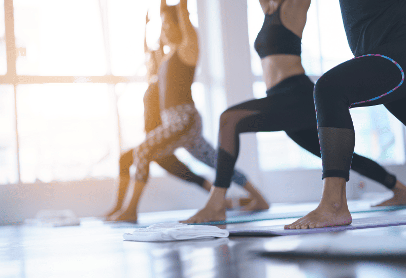 A group of women taking part in a yoga class offered by a fitness studio that creates a social and collaborative environment to improve retention rates